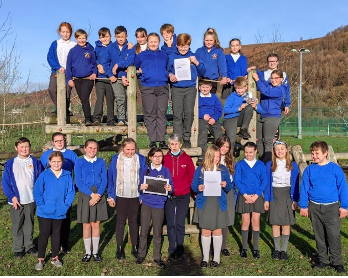 Pupils in Year 6 in Ynysowen Community School with the paper that they contributed to. Photo credit: Helen Usher