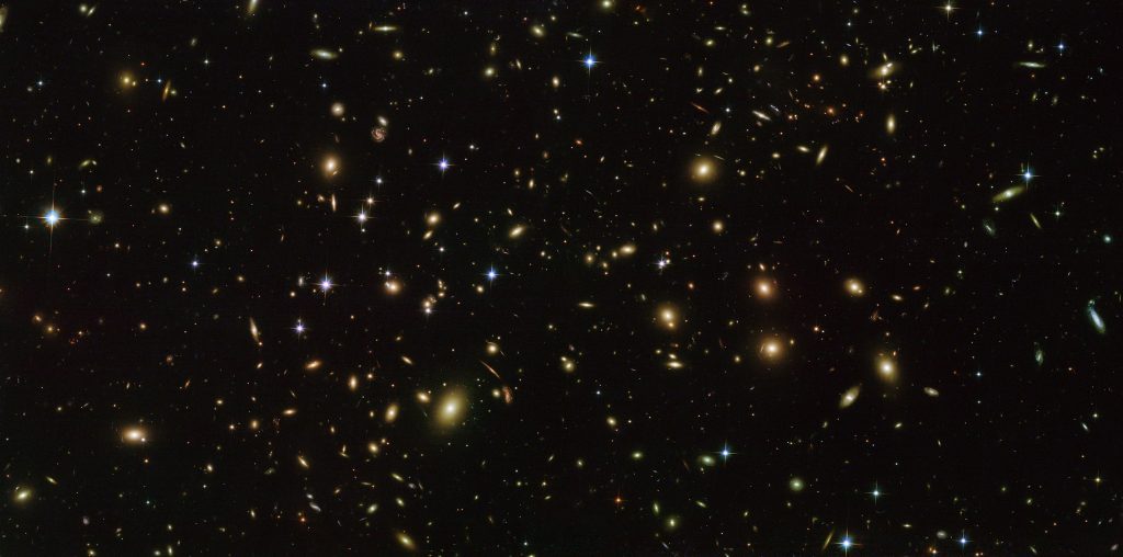 Figure 1. Abell 2163, a distant cluster of galaxies, all receding from us. (Source Wikimedia Commons, originator NASA/ESA/Hubble)