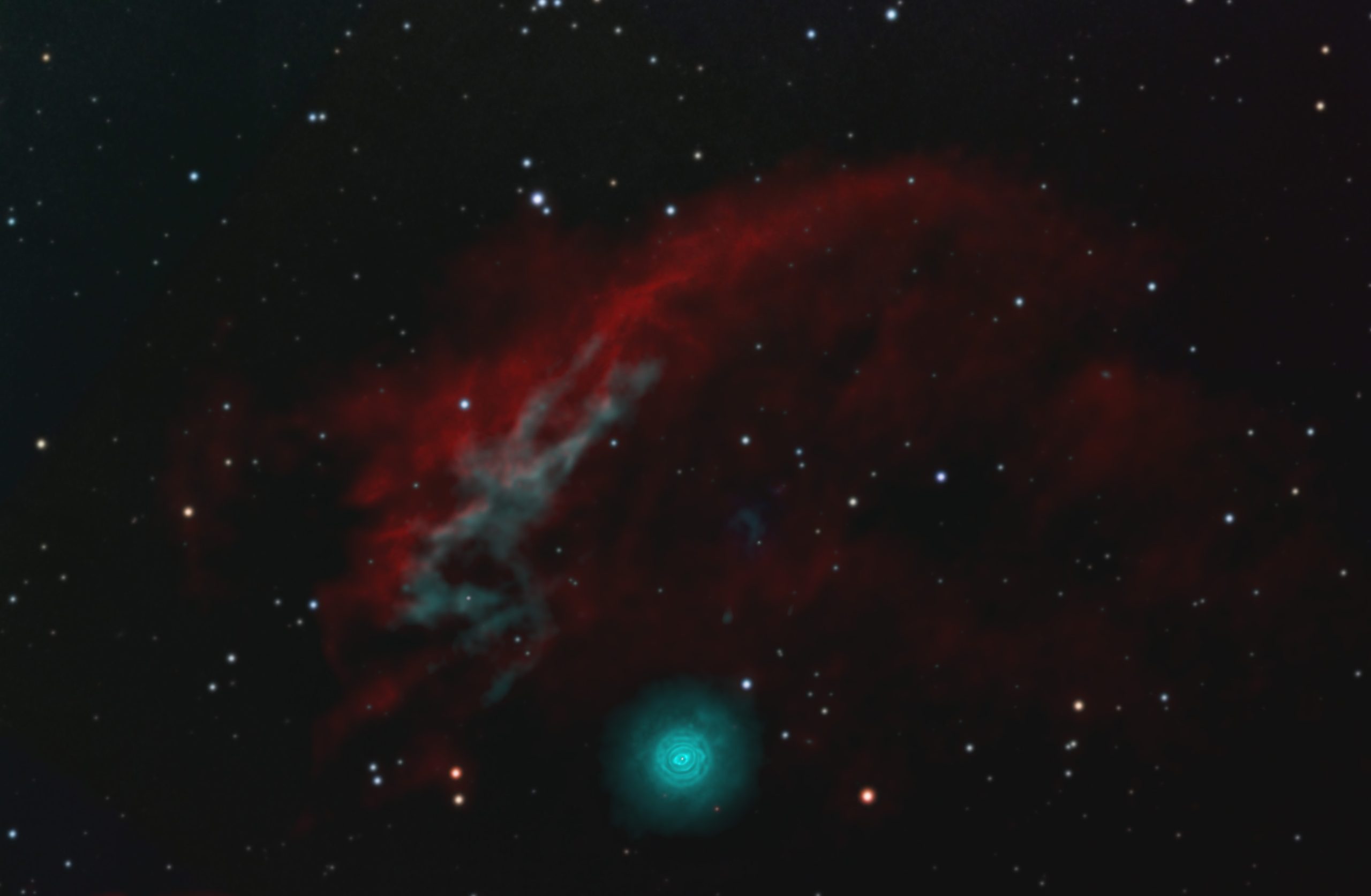 Condensed, spherical bluish nebula with arc of more diffuse red nebulosity above it