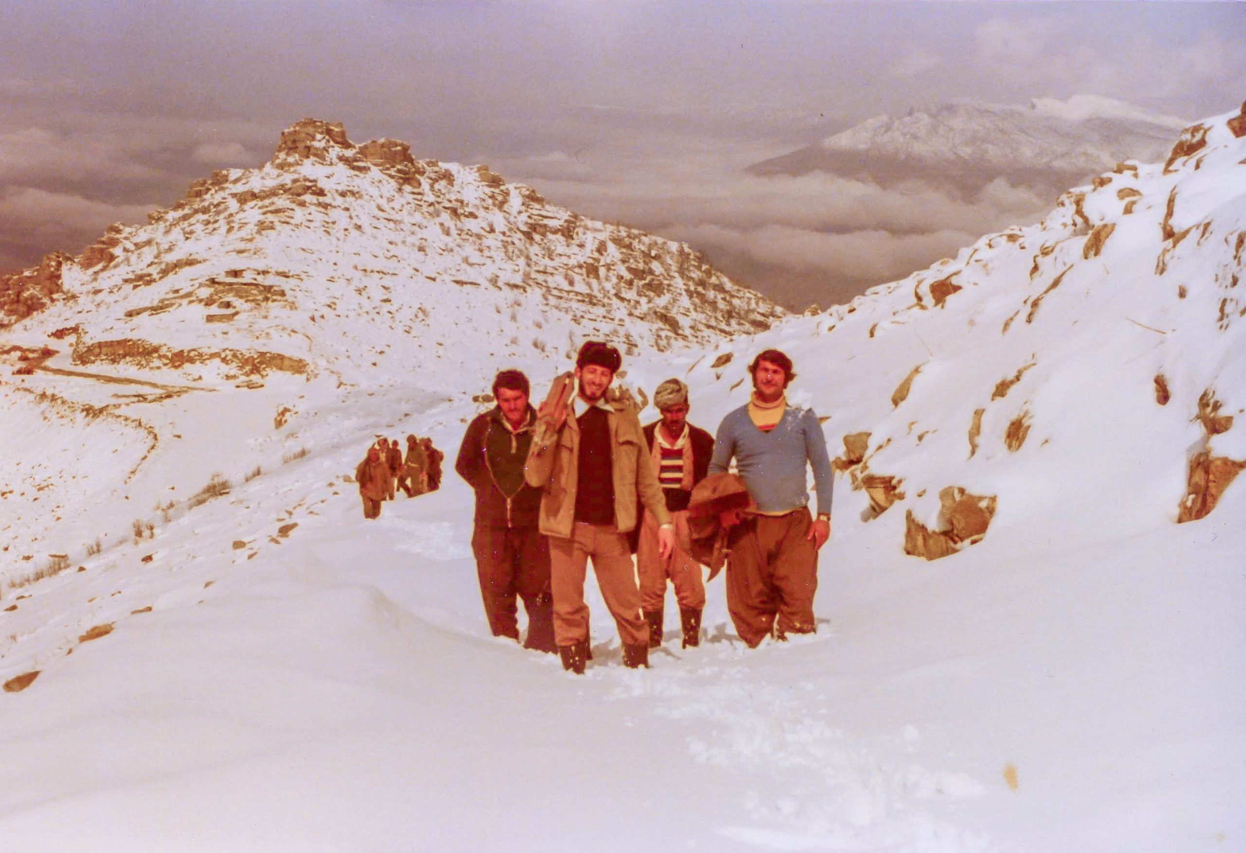A small group of people, including Mazin Younis, pose for the camera as they ascend the snowy slopes of Mount Korek