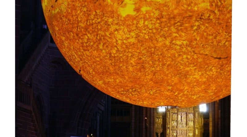 A large sun art installation in a cathedral